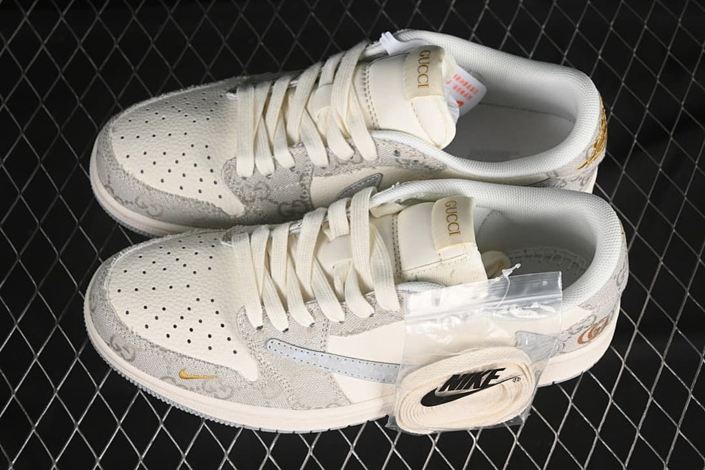 Top view of a pair of off-white and gray low-top sneakers with gold-tone accents and an extra set of laces.