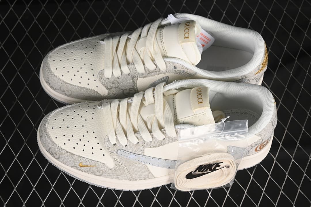 Top view of a pair of off-white and gray low-top sneakers with gold-tone accents and an extra set of laces.