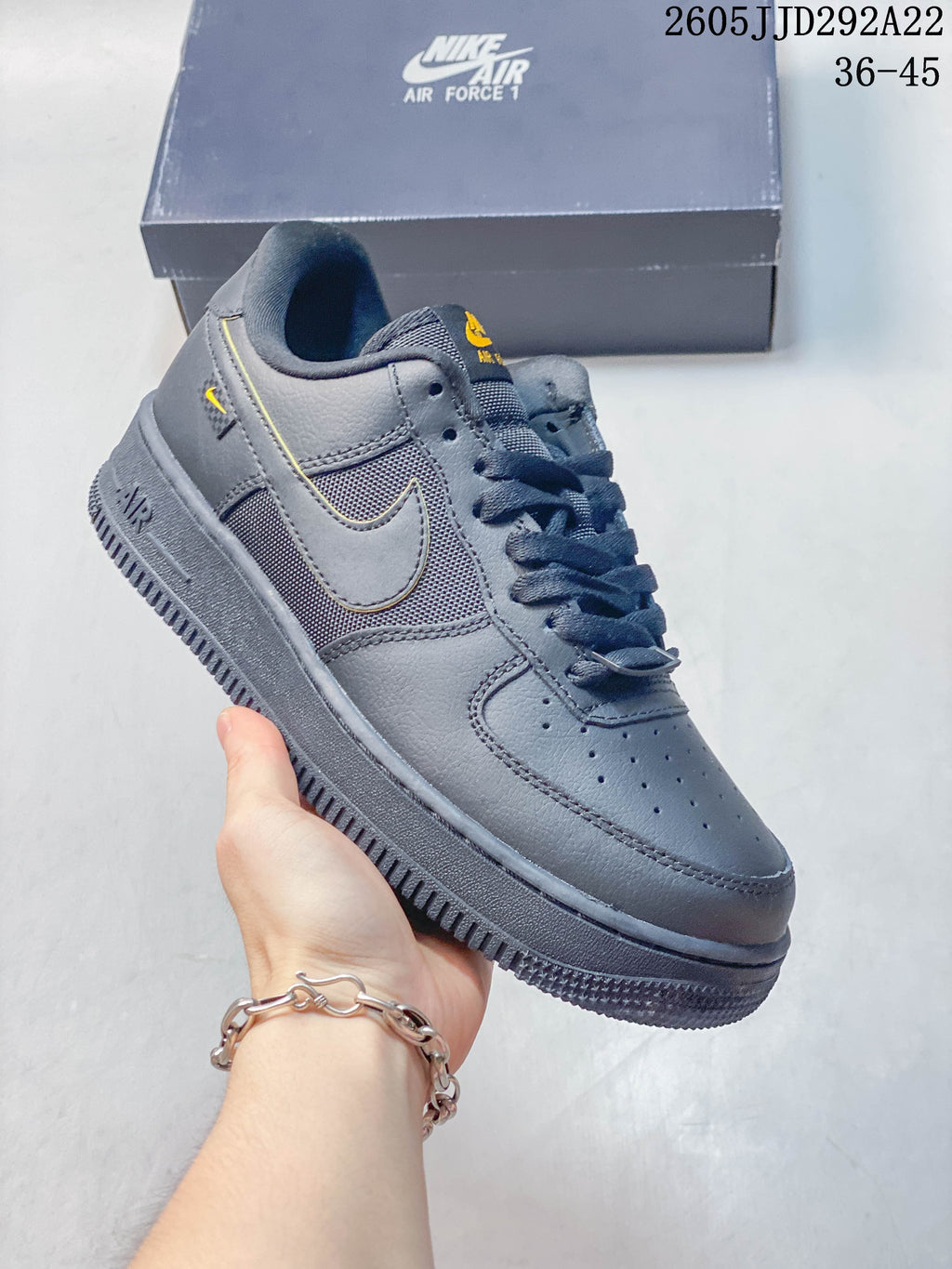 Dark gray low-top sneaker with mesh-look side panels and yellow accents