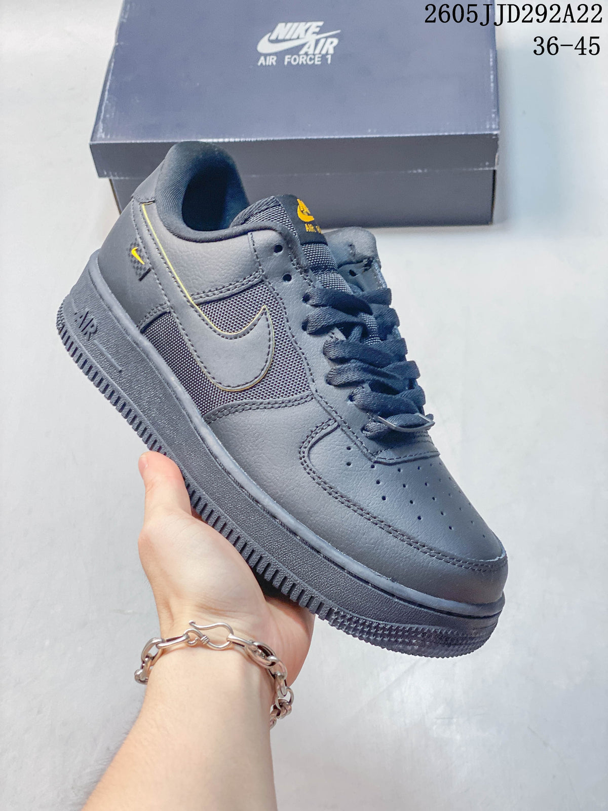 Dark gray low-top sneaker with mesh-look side panels and yellow accents