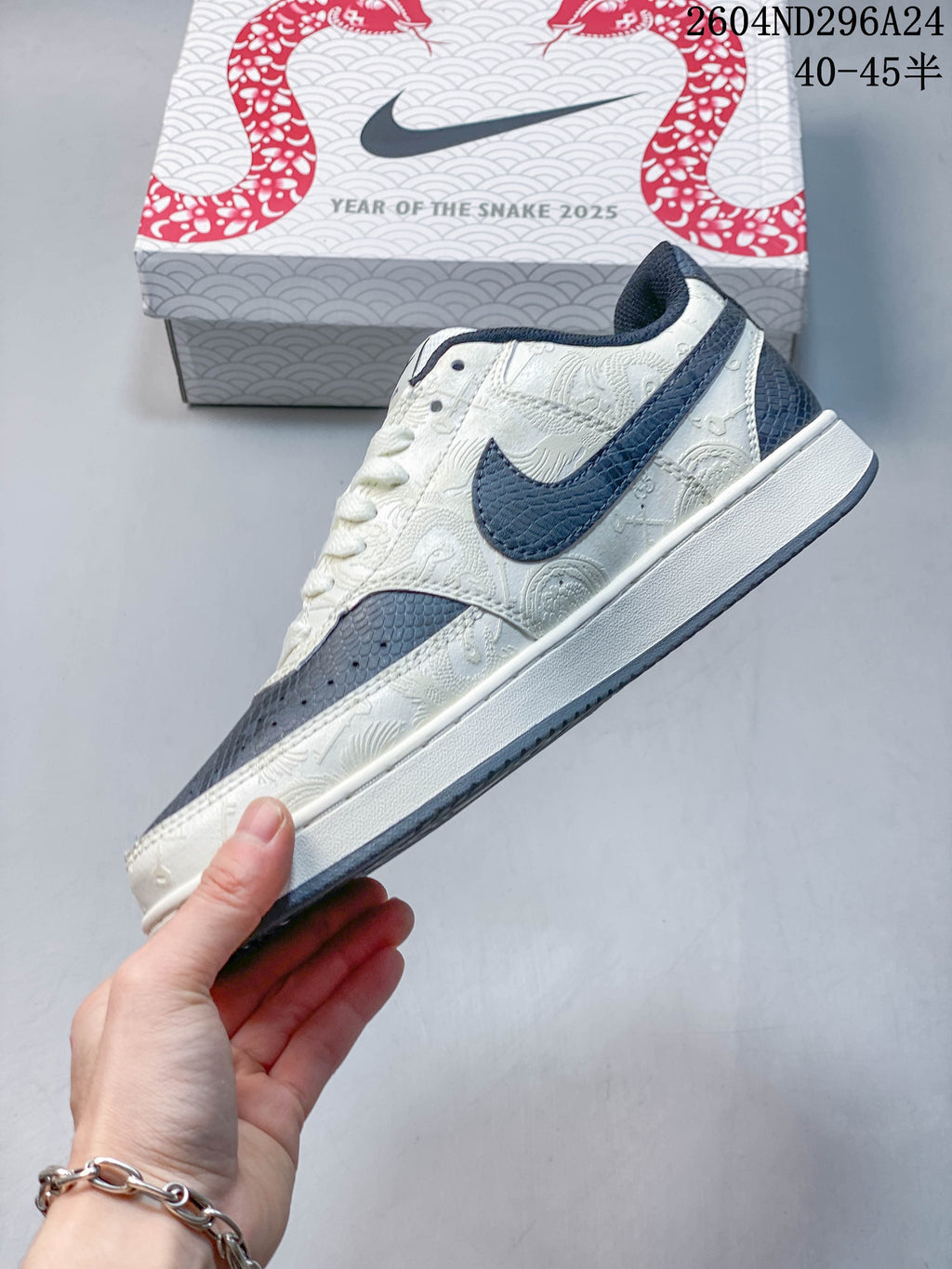 Side view showing the patterned off-white panels and slate-blue accents on the low-top sneaker