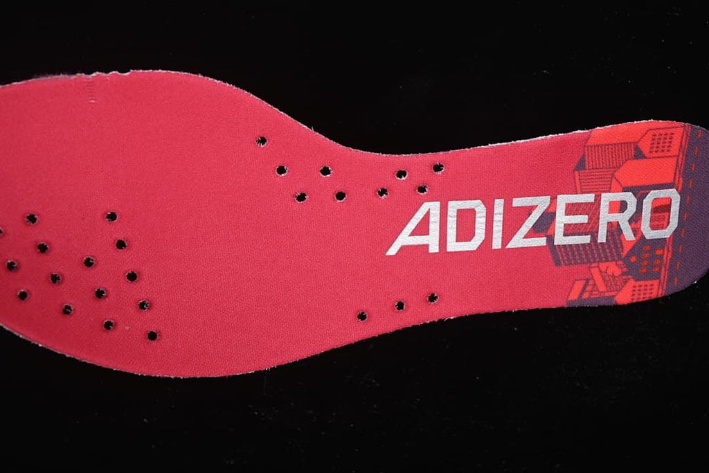 Close-up of the red Adizero insole with perforations