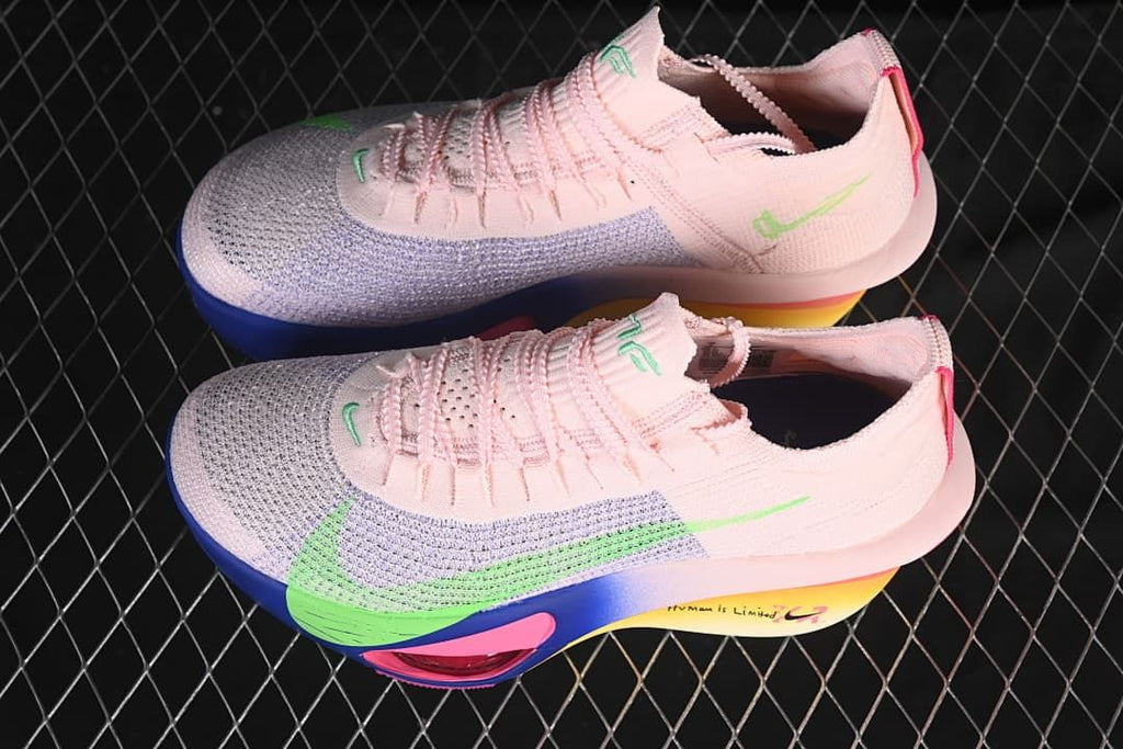 Pair of pink running shoes with green accents and multicolor soles