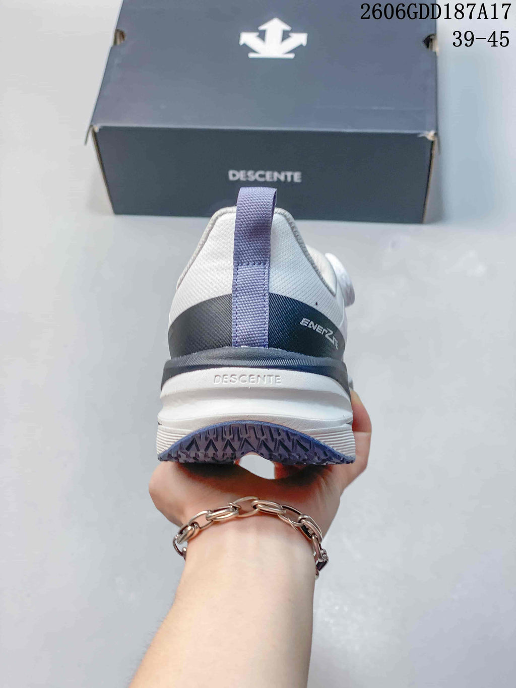 Rear view of a white DESCENTE sneaker with gray heel detail