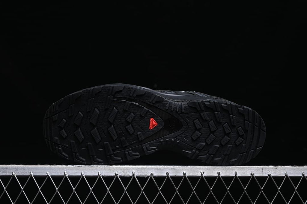 Underside showing the lugged black outsole and red Salomon mark