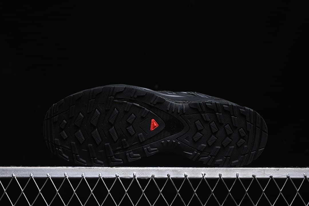 Underside showing the lugged black outsole and red Salomon mark