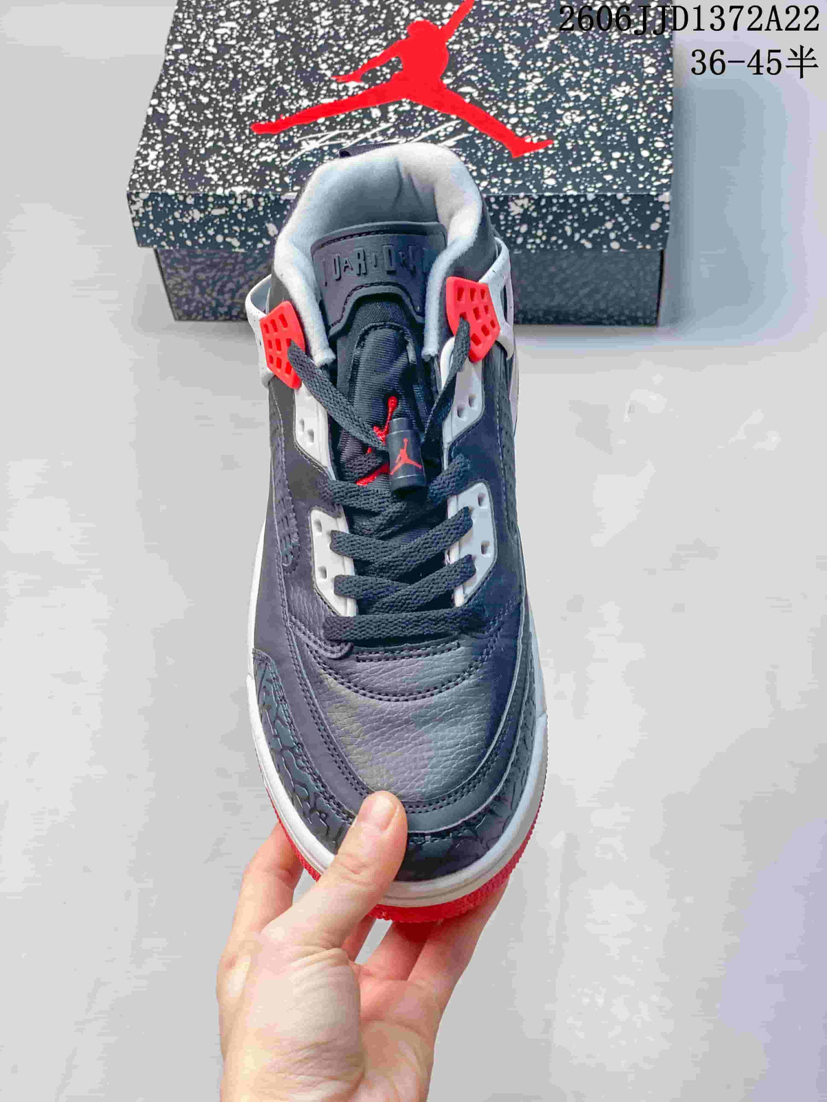 Front view of a charcoal Jordan Spizike Low sneaker with dark laces and red details