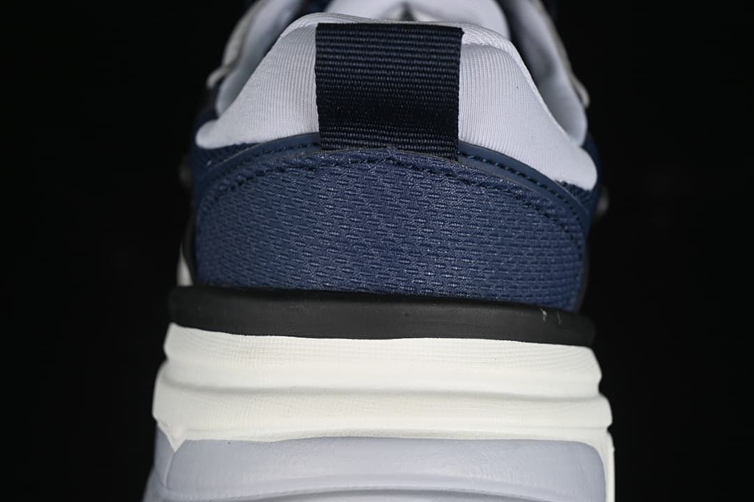 Rear close-up of the navy heel, pull tab and layered sole