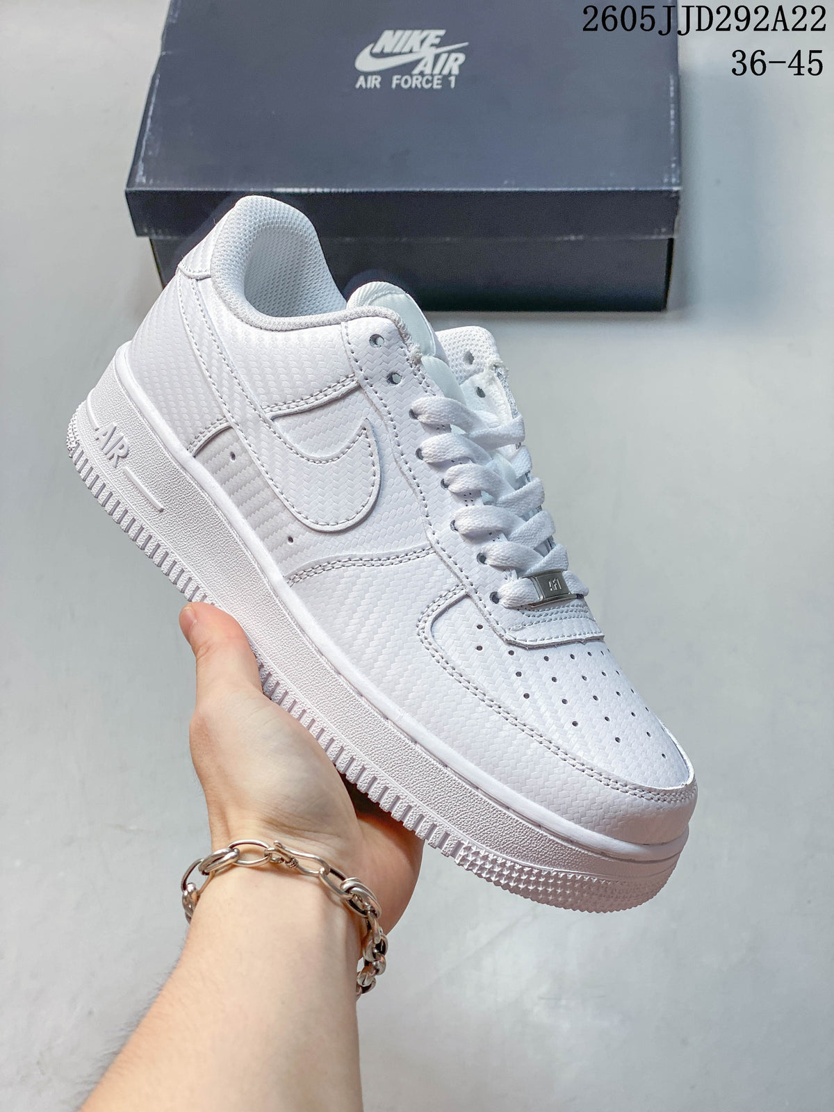 White low-top sneaker with textured panels and tonal Swoosh