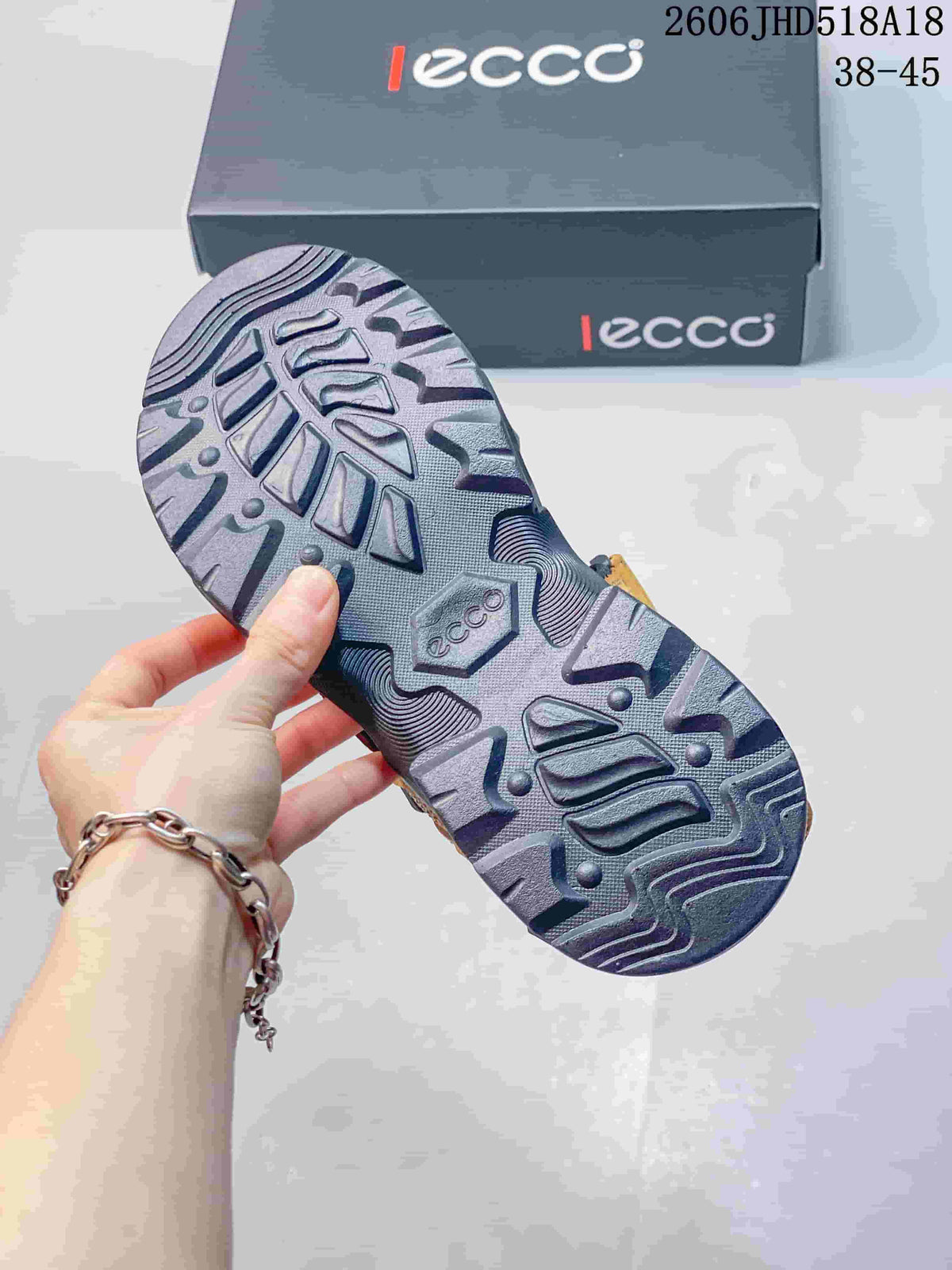 Close-up of the patterned outsole of an orange and gray sandal.