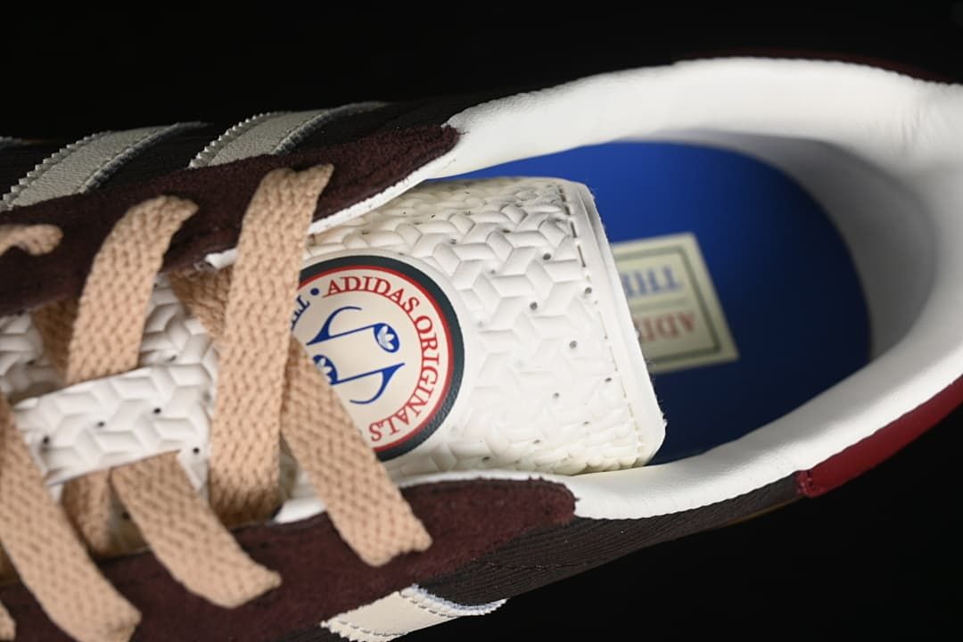 Top view inside the sneaker showing the tongue patch, beige laces, and blue insole.