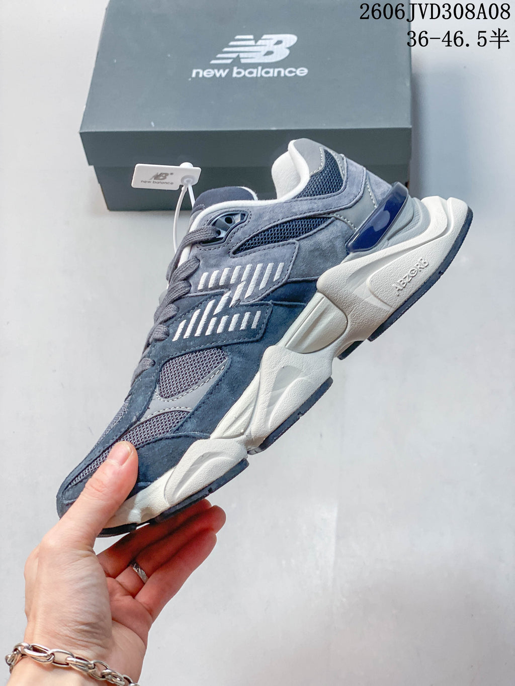 Side view of a blue-grey New Balance 9060 sneaker with layered panels and mesh