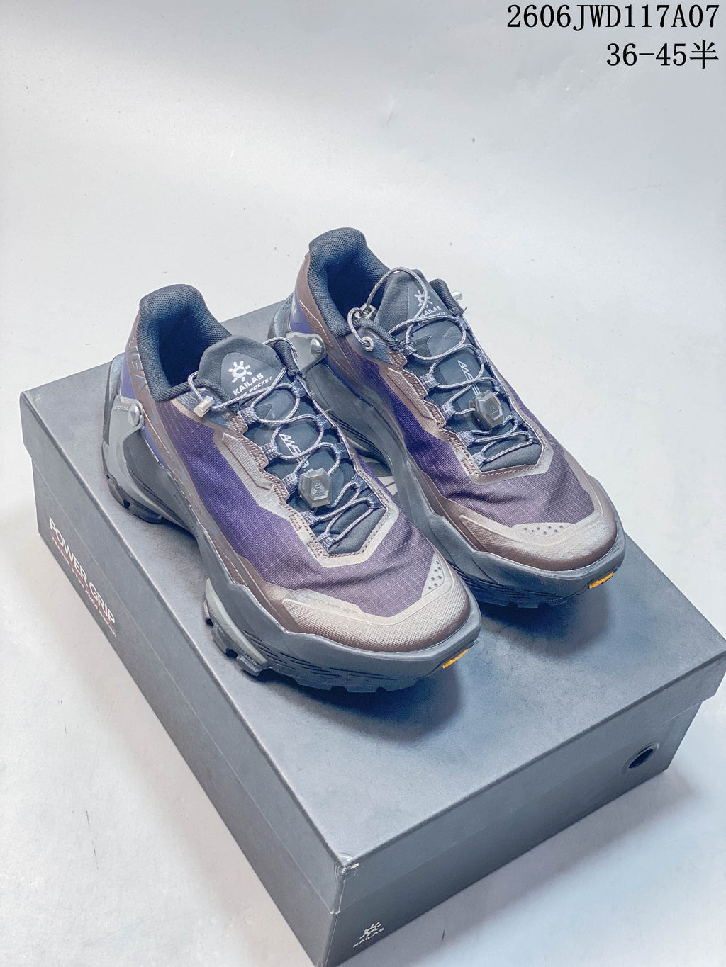 Pair of KAILAS FUGA DU 2 low-cut trail running shoes in purple, gray, and taupe, shown on a shoe box.