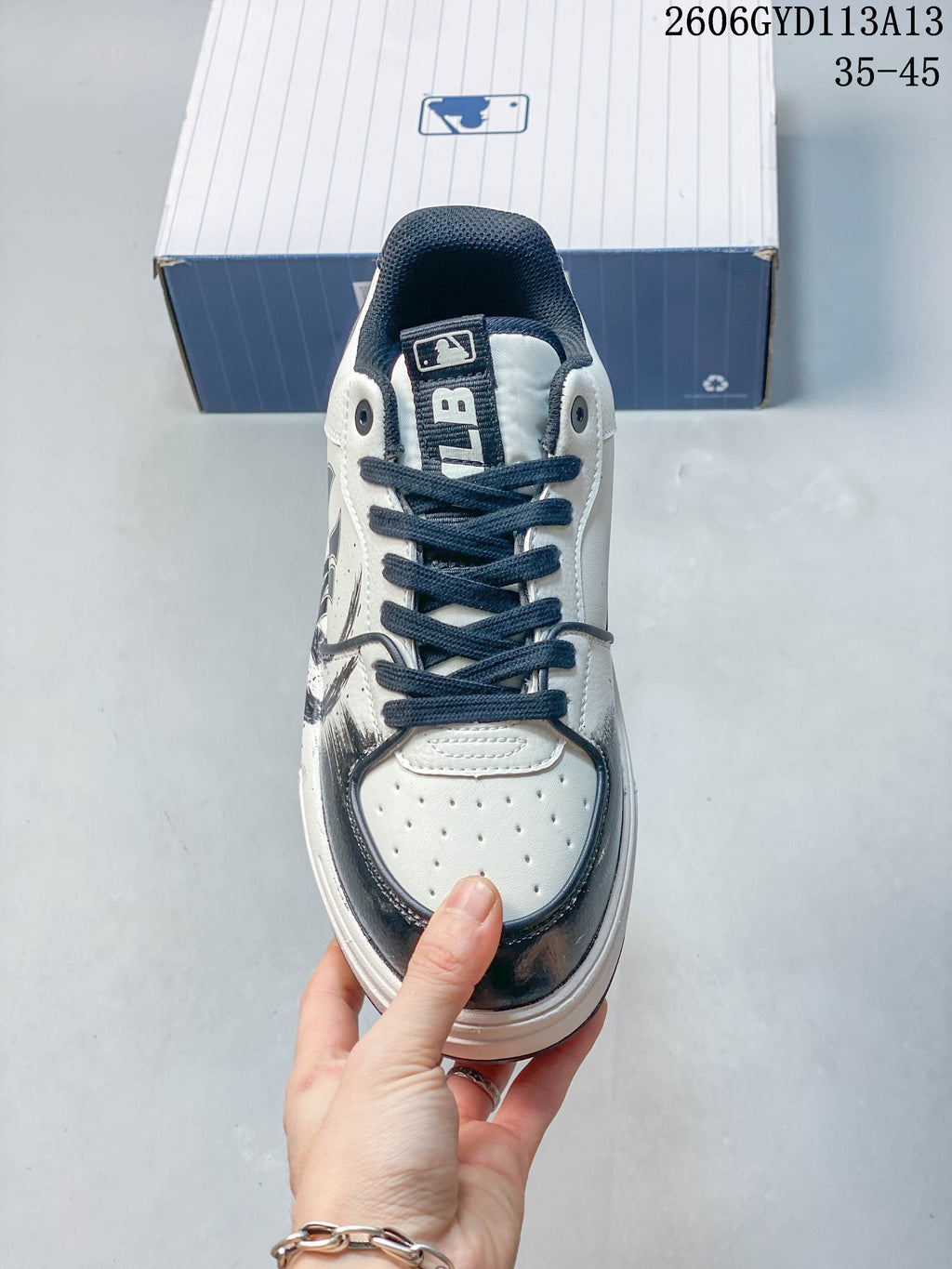 Front view of the sneaker showing navy laces and a perforated toe