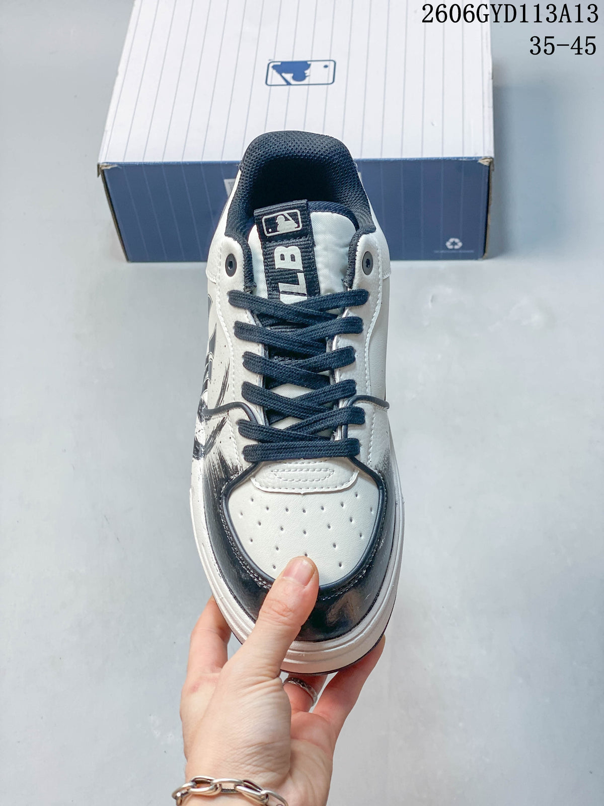 Front view of the sneaker showing navy laces and a perforated toe