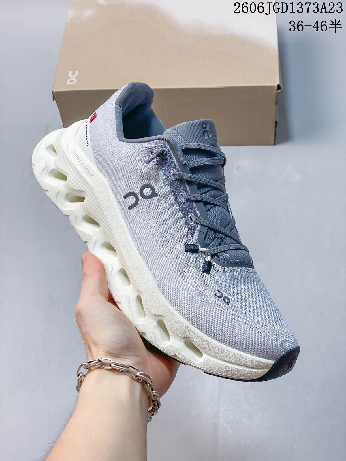 Angled view of a gray and white On sneaker with a sculpted sole