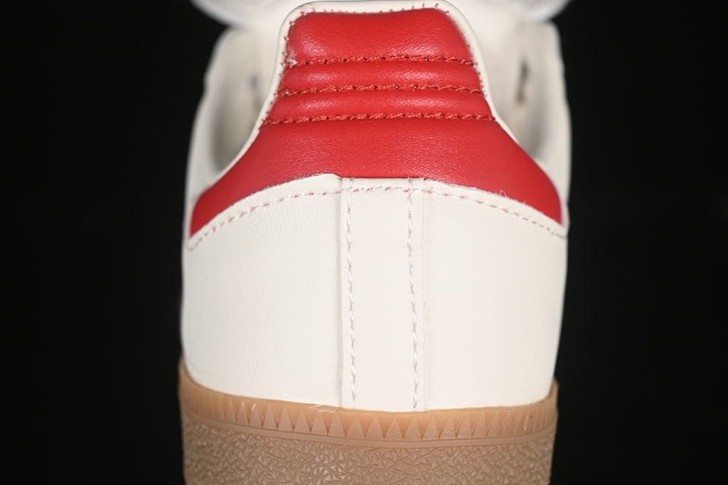 Rear view showing the red heel panel, off-white upper, and gum outsole.