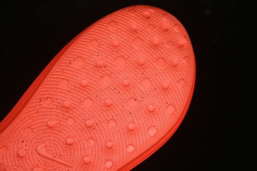 Close-up of the patterned outsole on the orange clog sandal