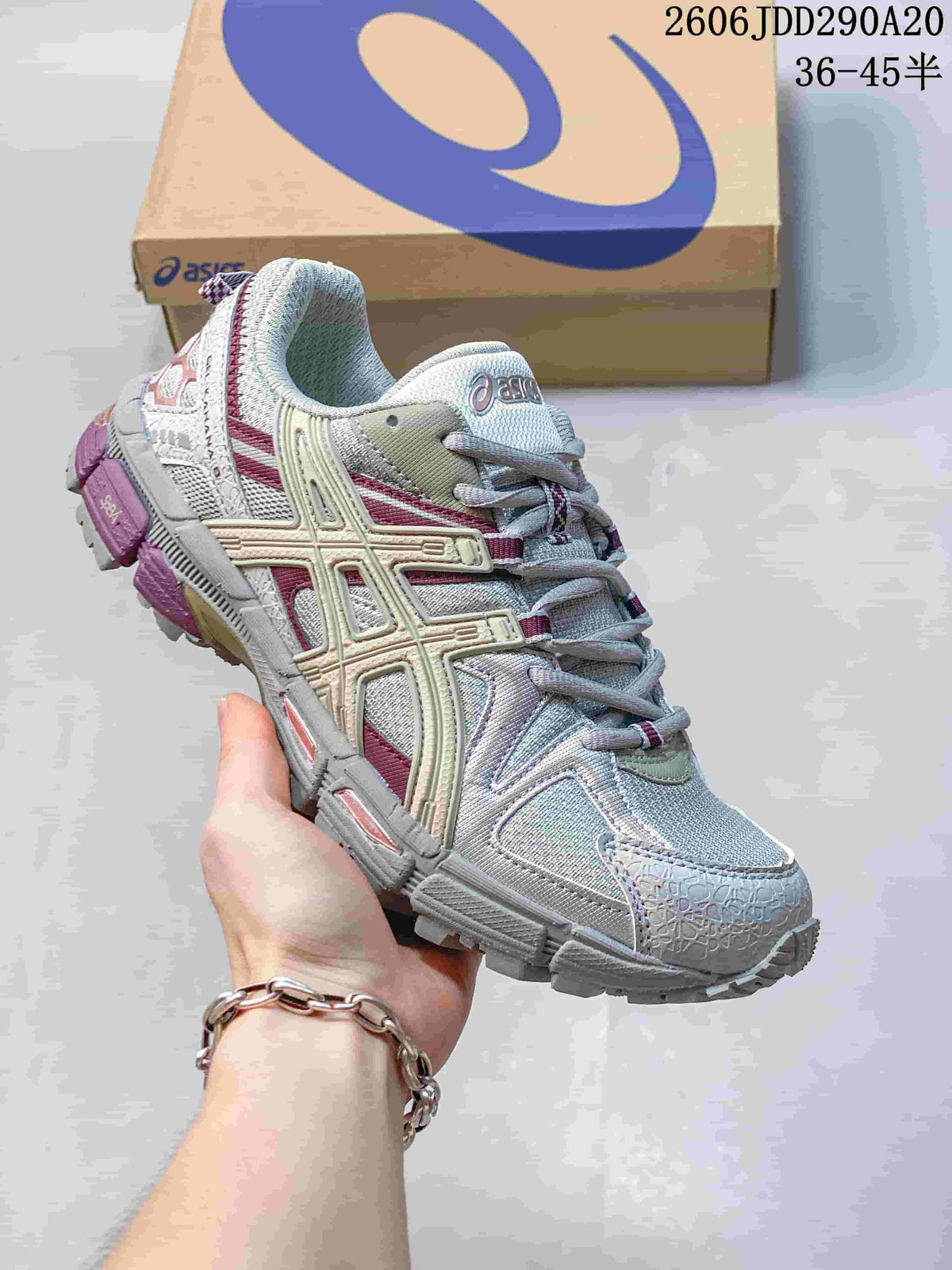 Close-up of a light gray ASICS Gel-Kahana 8 sneaker with muted pink and cream details.