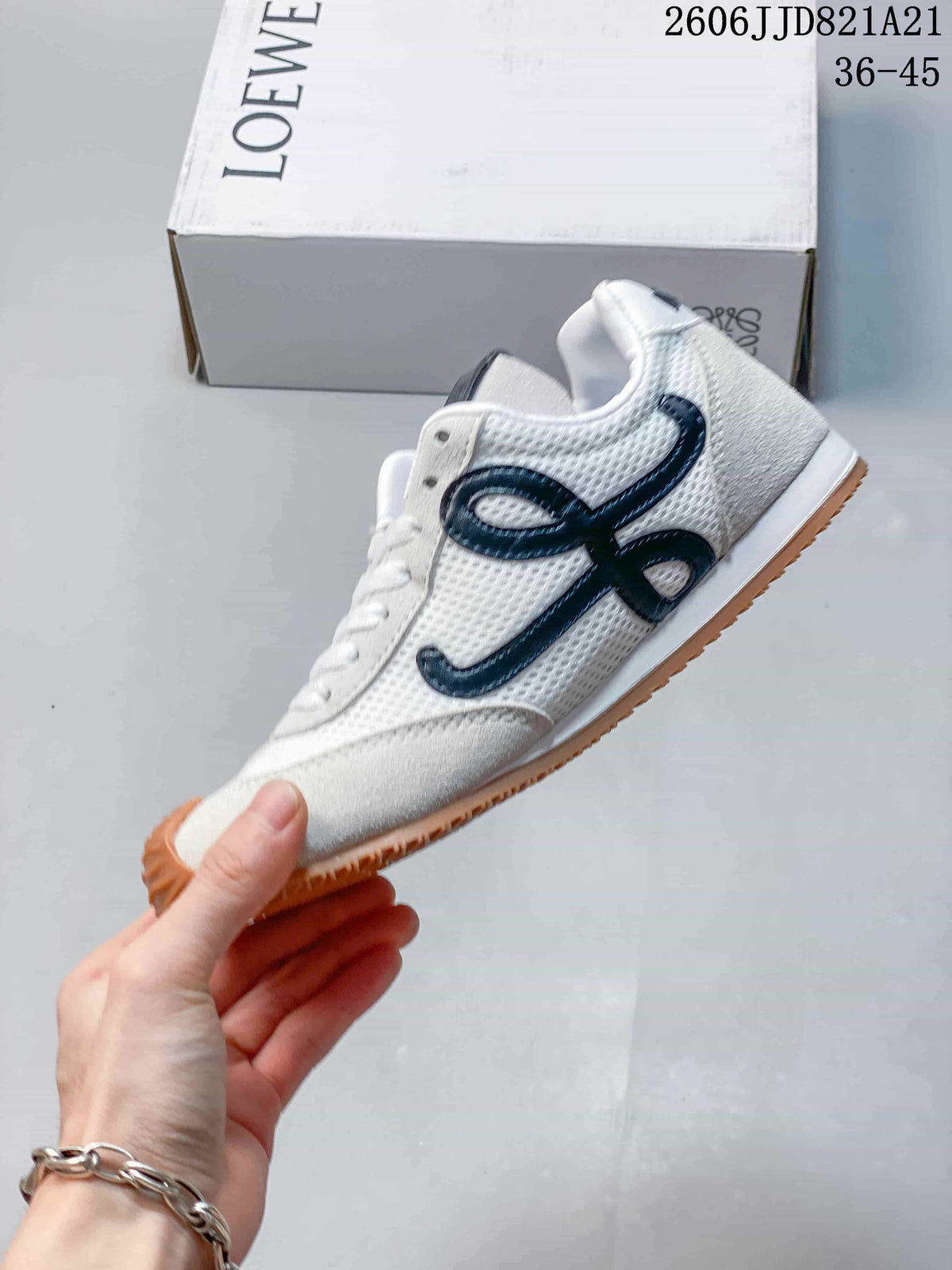 Side view of the sneaker with white mesh panels, light gray overlays, black detailing, and a gum-colored sole.