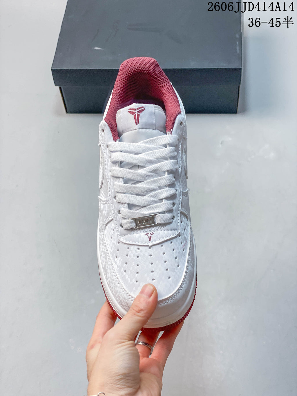 Top view showing white laces, a perforated toe, and burgundy-red collar lining