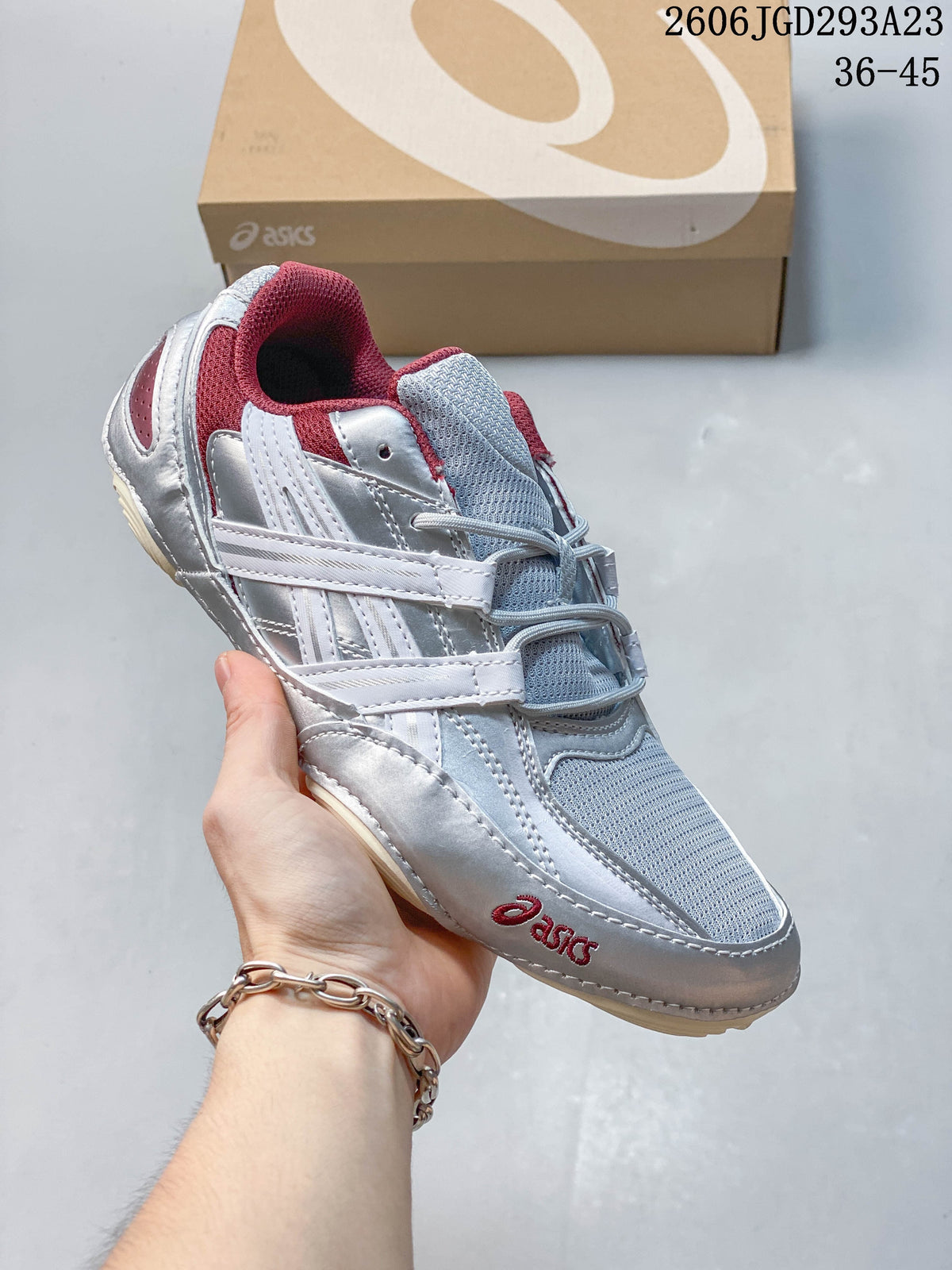 Silver and pale blue ASICS Gel-Pickax sneaker with burgundy accents, shown with a shoe box.