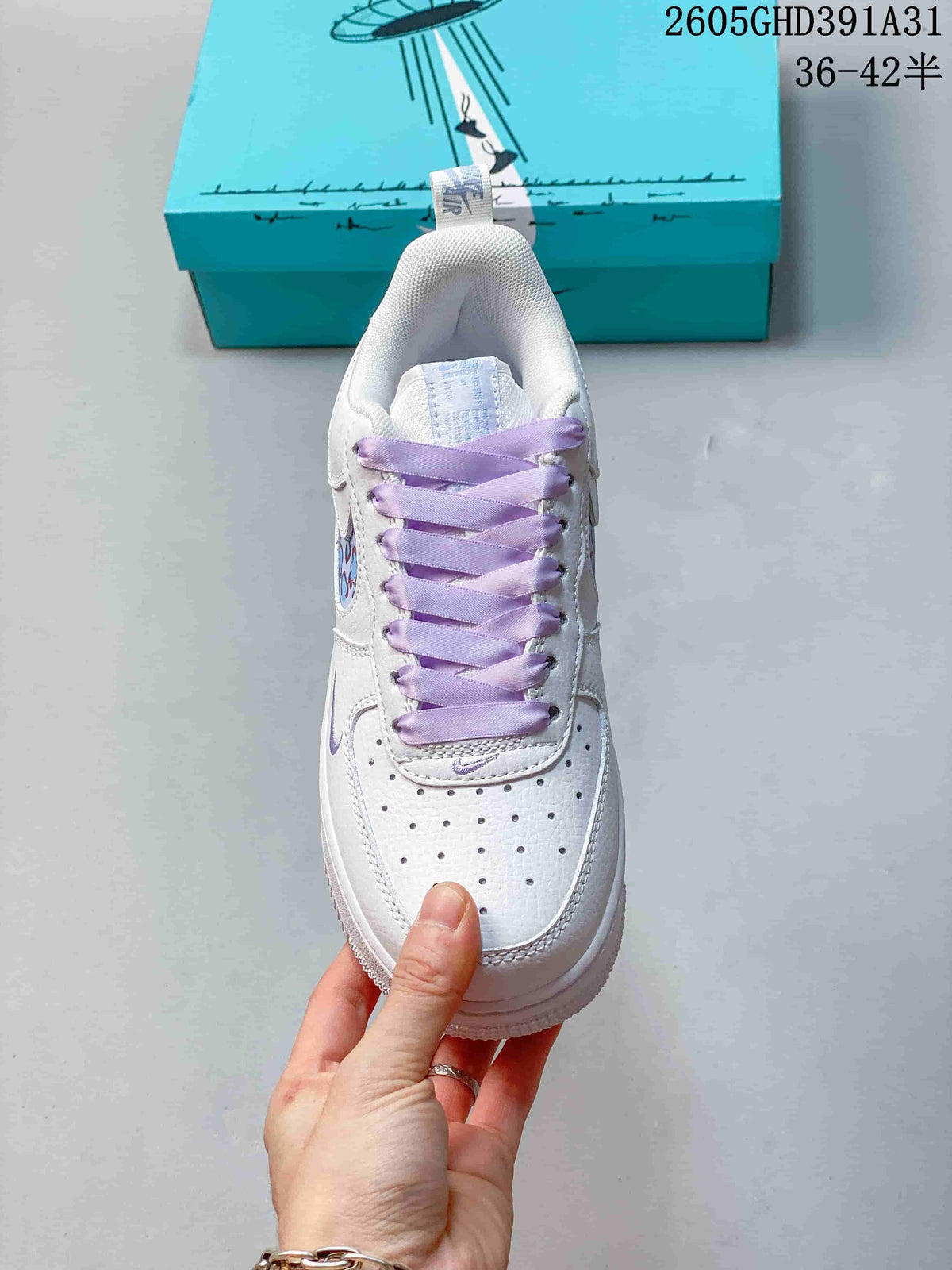 Top view of a white low-top sneaker with lavender laces, a perforated toe, and patterned side detail