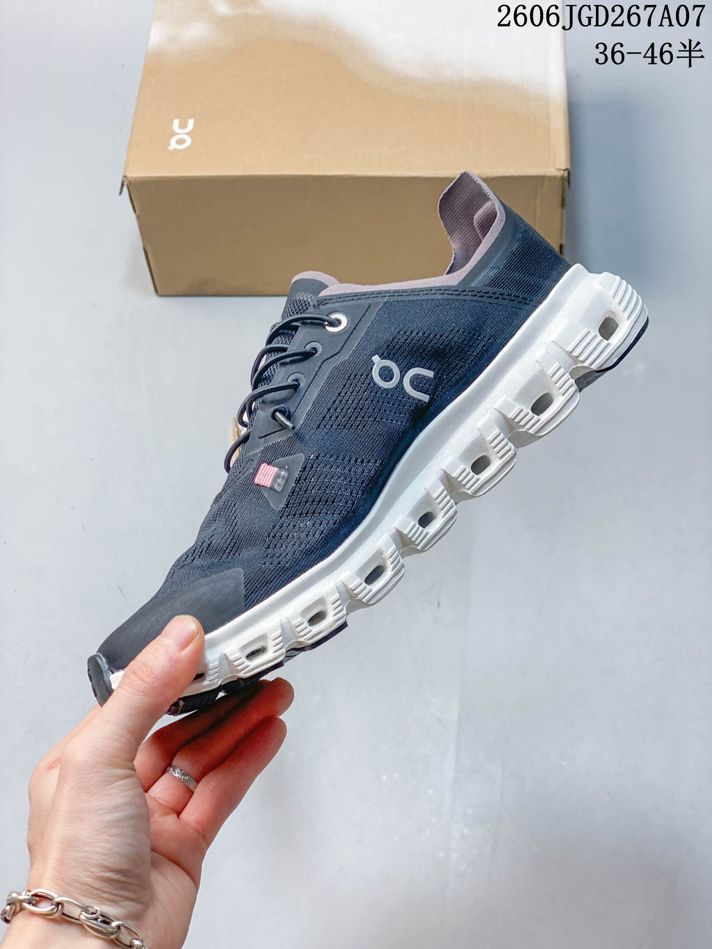 Side view of a dark navy low-top shoe with lace-up fastening and a white segmented outsole.