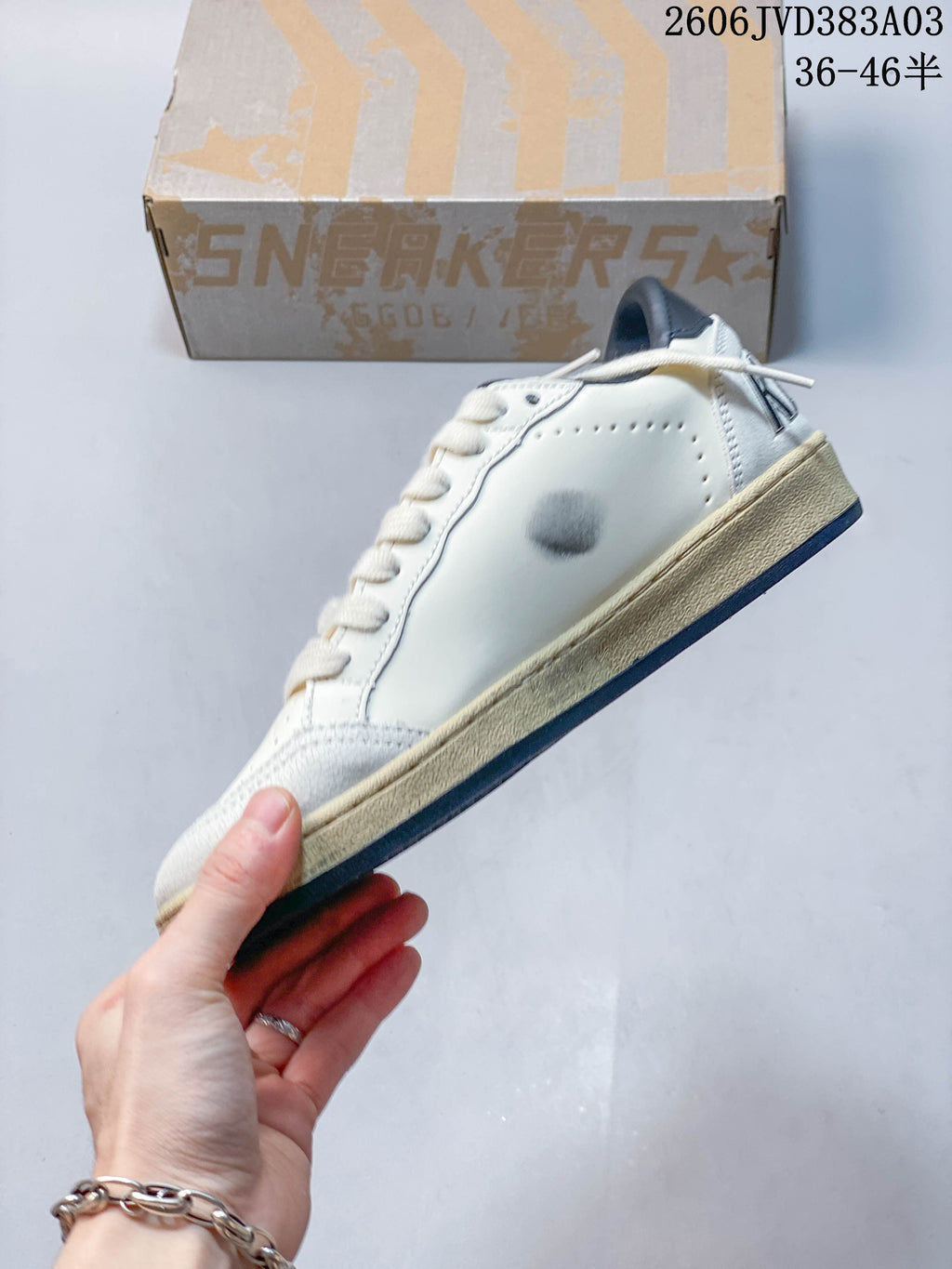 Side view of off-white sneaker with a star detail and distressed-looking midsole