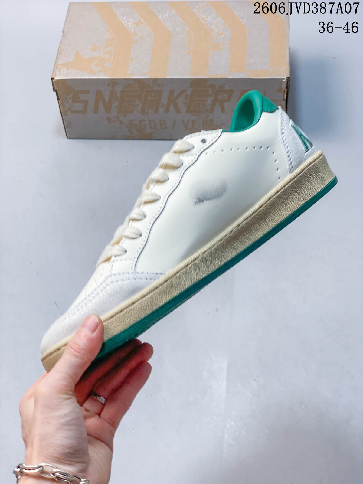 Side view of the white sneaker with green accents and a beige sole.
