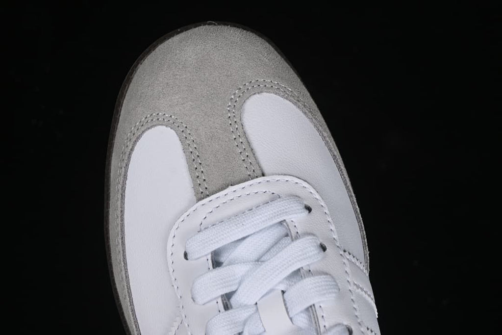 Top view of the gray toe panel, white leather-look panels, and laces