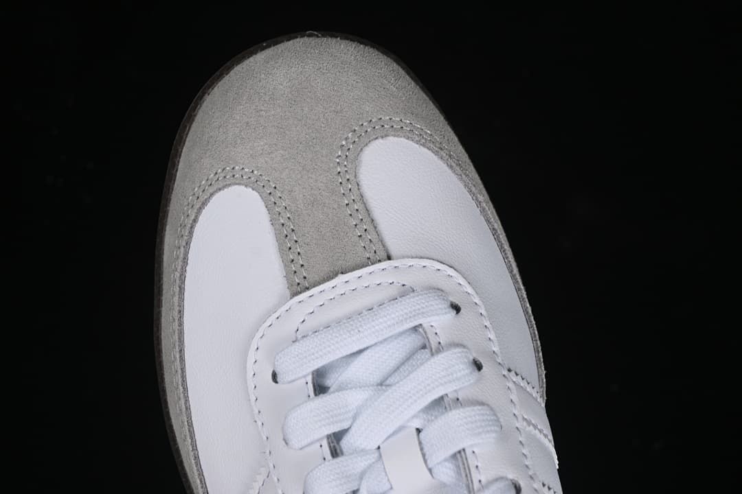 Top view of the gray toe panel, white leather-look panels, and laces