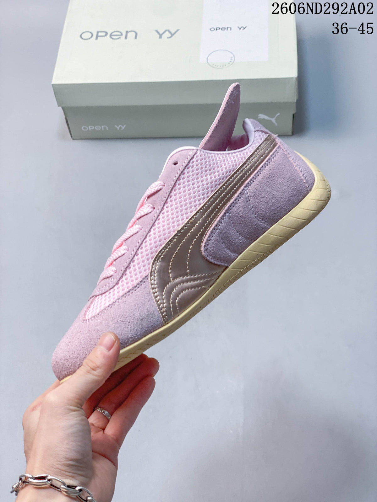 Side profile of the pink sneaker showing the metallic-look stripe, mesh panels and pale outsole.