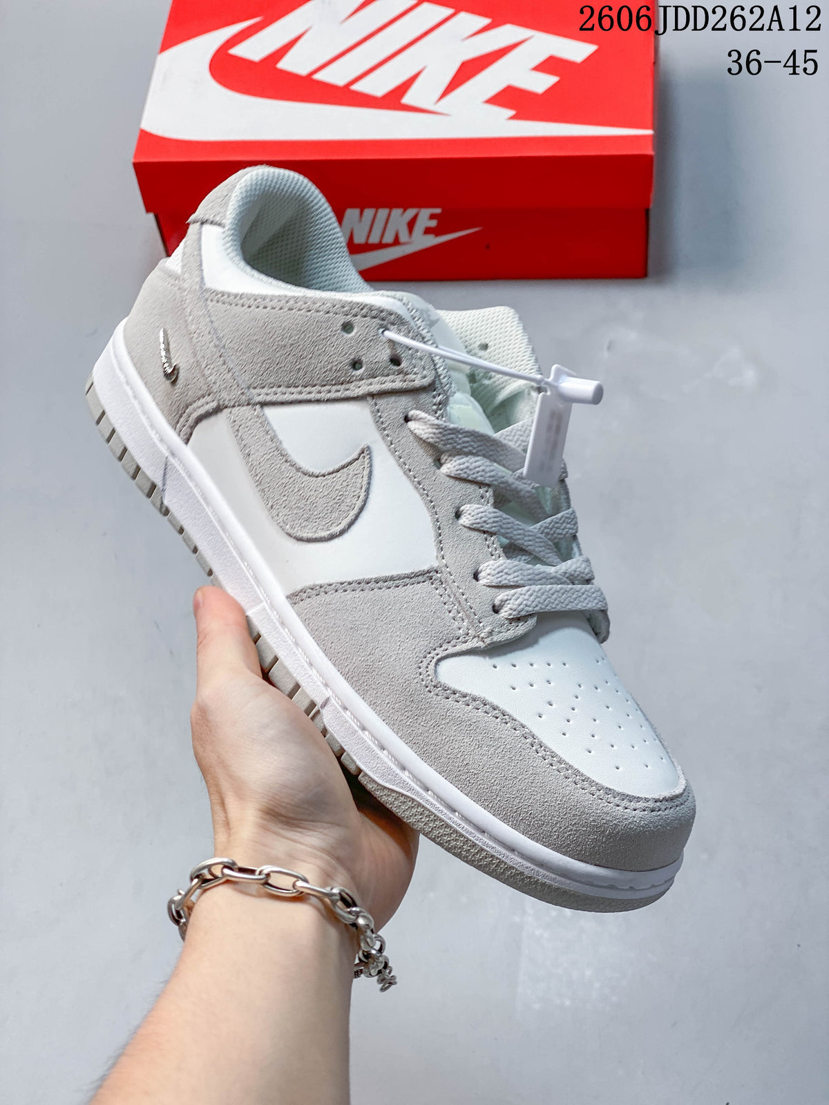 Angled side view of the Sail and grey Nike Mini Swoosh sneaker.