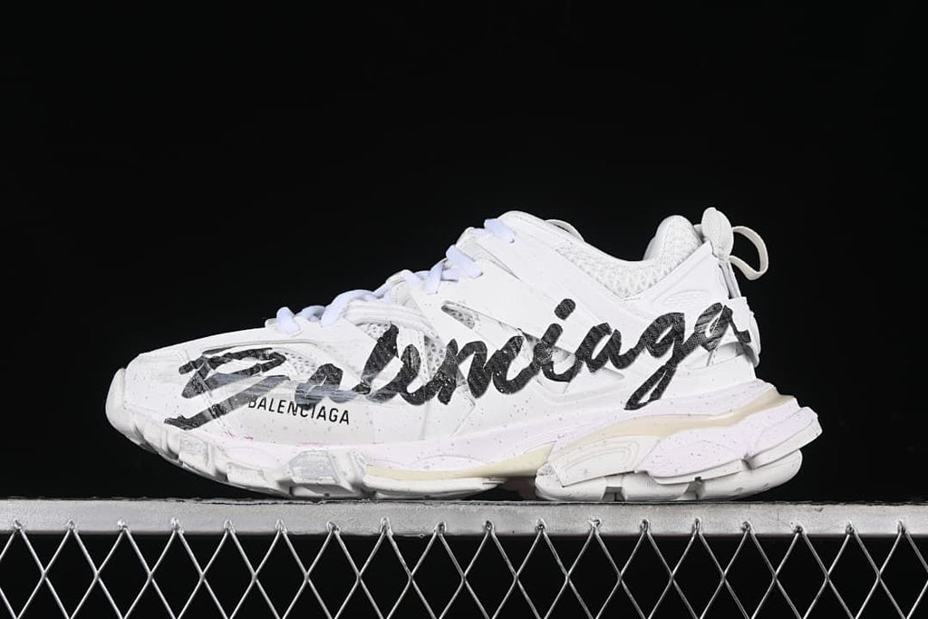 Side profile of the white sneaker with black handwritten-style graphics