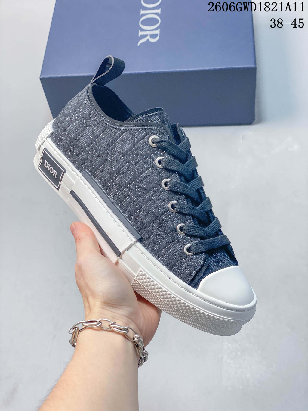 Angled side view of a gray patterned Dior B23 low-top sneaker with white sole and toe cap