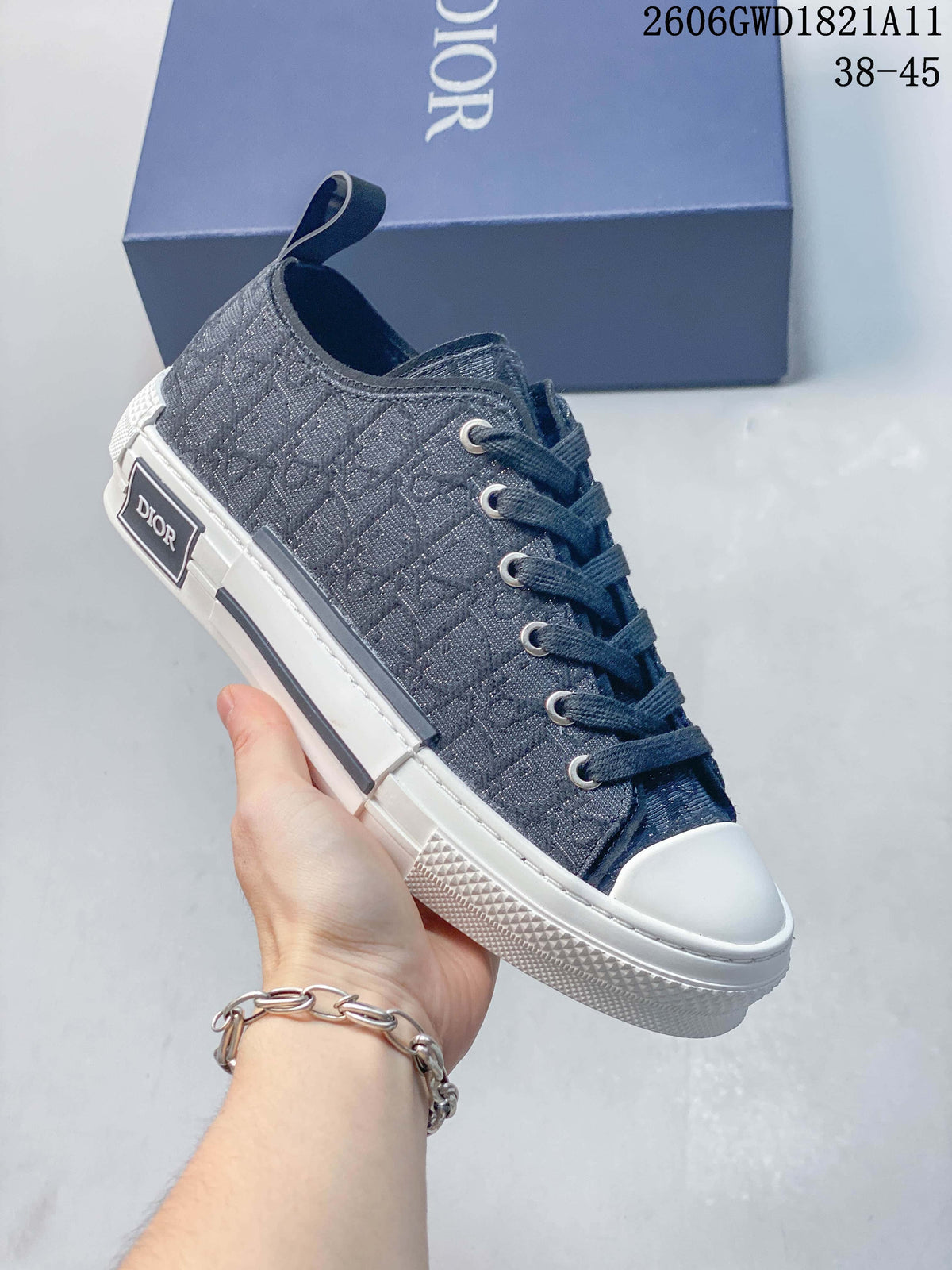 Angled side view of a gray patterned Dior B23 low-top sneaker with white sole and toe cap