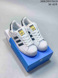 Pair of white Adidas Originals Superstar low-top sneakers with dark stripes and shell-style toes