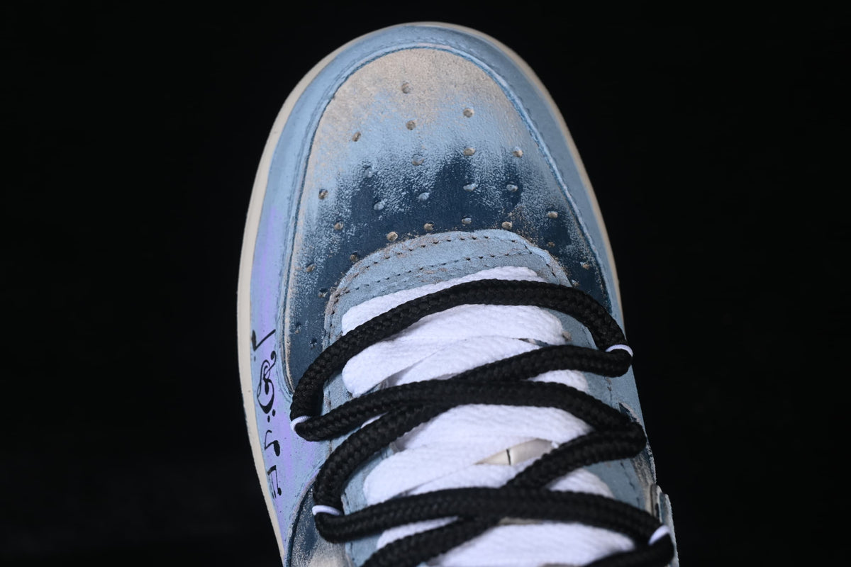 Top-down close-up of the blue and silver-toned perforated toe box and laces