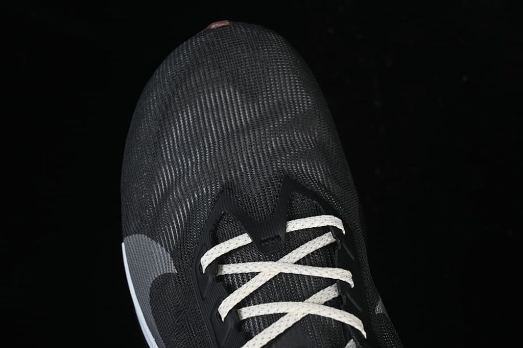 Top view of the dark shoe toe and light-colored laces.
