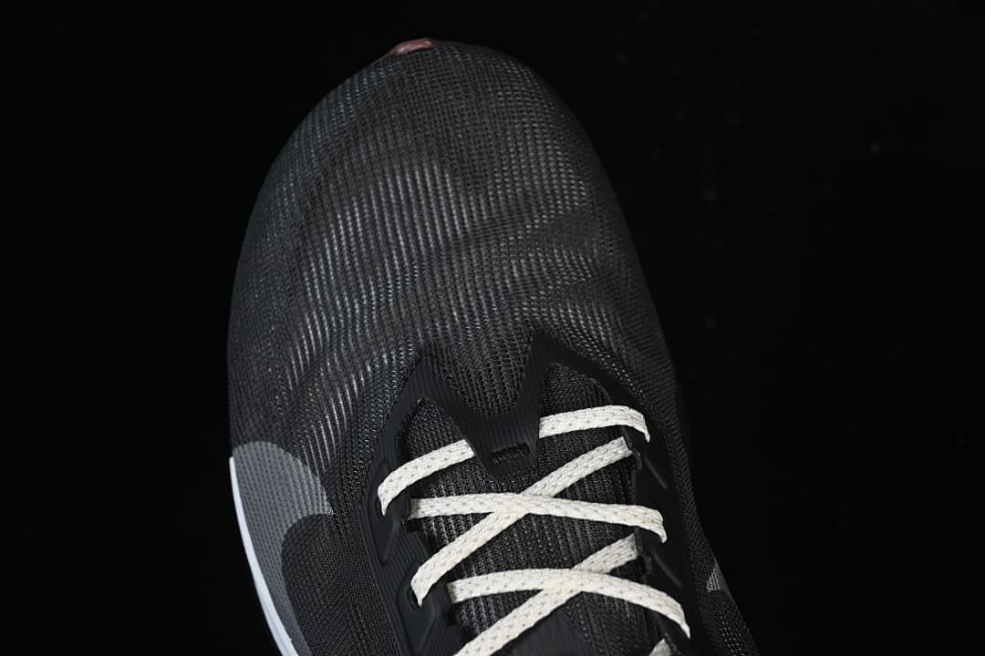 Top view of the dark shoe toe and light-colored laces.