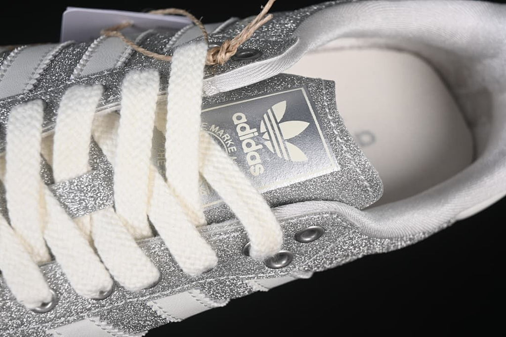 Top detail of the laces, tongue branding and silver glitter-effect panels.