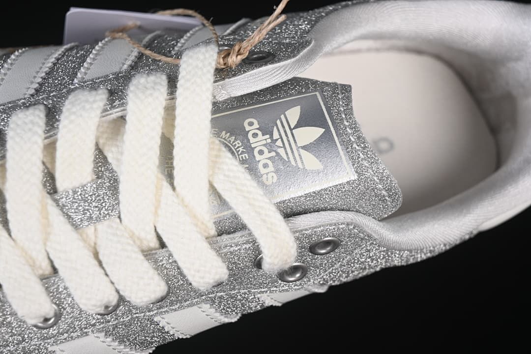 Top detail of the laces, tongue branding and silver glitter-effect panels.
