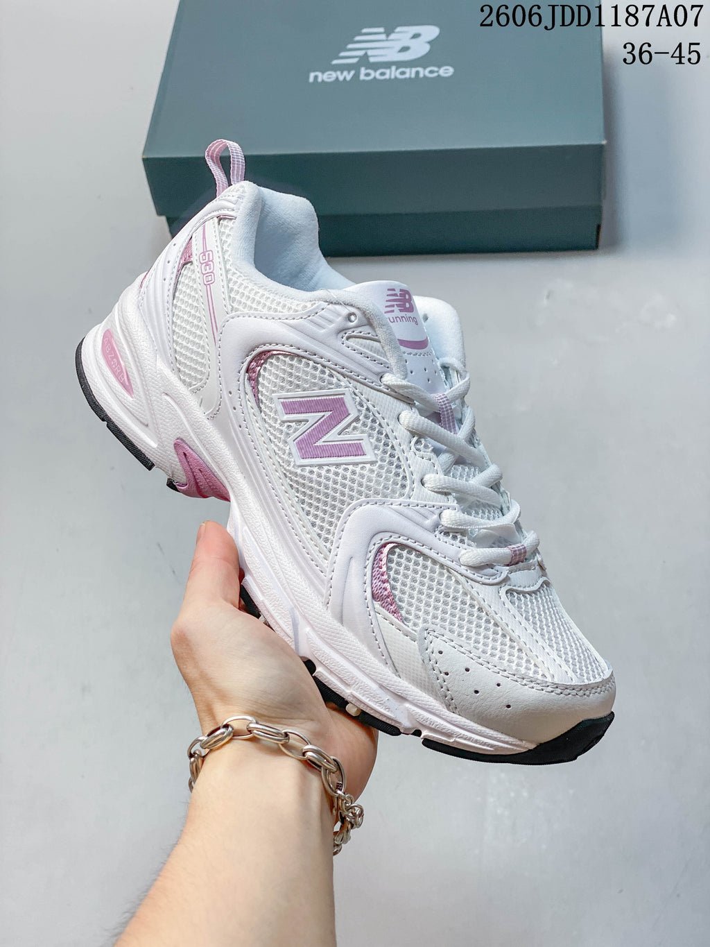 Angled side view of a white and pink New Balance 530 sneaker