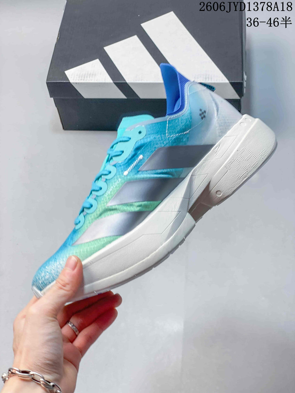 Side profile showing the turquoise patterned upper, silver stripes, and sculpted white midsole