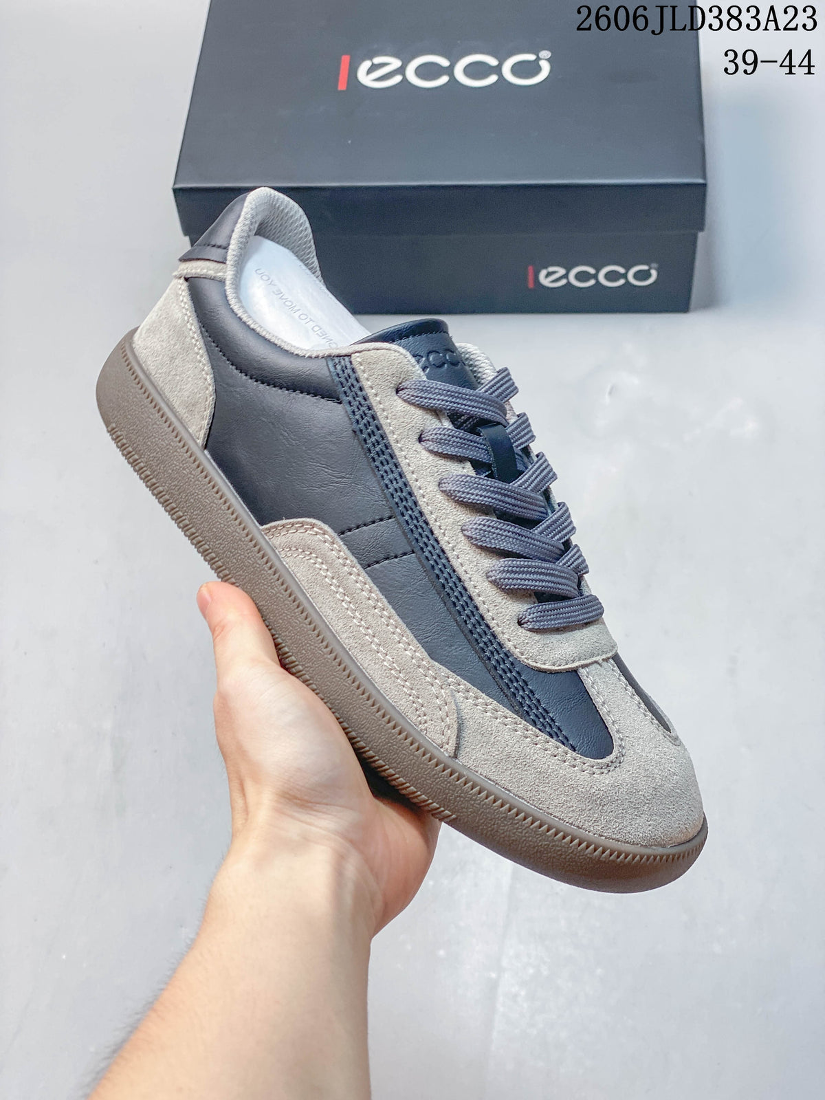 Side view of a gray and navy ECCO lace-up sneaker with layered panels