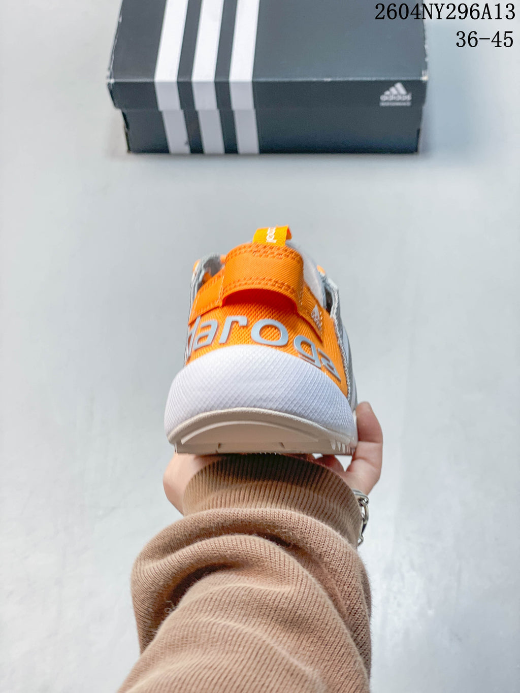 Rear view of the shoe with an orange heel panel and pull tab.