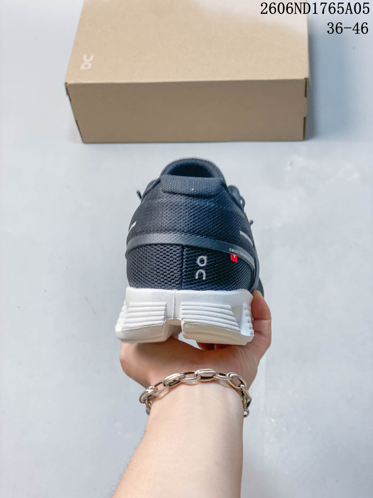 Rear view of a charcoal On Cloud 5 sneaker with a white sole