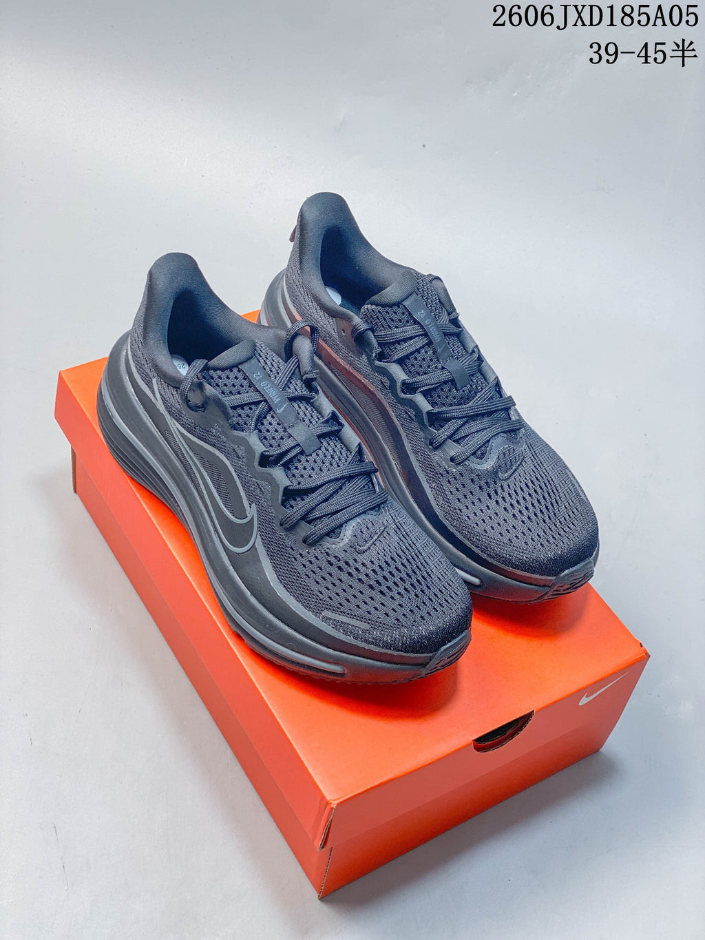 Pair of dark gray Nike Winflo 12 running shoes displayed on an orange box.