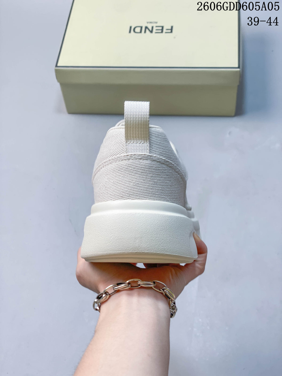 Rear view of a cream sneaker with a pull tab and thick sole